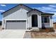 Charming single-Gathering home with a grey exterior, attached garage, and a cozy front porch with white railings at 1613 Bloom St, Brighton, CO 80601