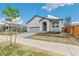 Charming home featuring gray siding, a cozy porch, and a well-maintained lawn at 1613 Bloom St, Brighton, CO 80601