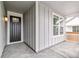 Inviting front porch with gray siding and a black front door at 1613 Bloom St, Brighton, CO 80601
