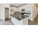 Modern kitchen boasts white cabinets, stainless steel appliances, and island with stone countertops at 1613 Bloom St, Brighton, CO 80601