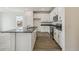 Well-lit kitchen features white cabinets, stainless steel appliances, and a dark countertop island at 1613 Bloom St, Brighton, CO 80601
