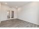 A spacious living room shows great natural light from glass paneled doors with wood look floors at 1613 Bloom St, Brighton, CO 80601