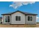 Back exterior featuring gray siding, contrasting trim, and large sliding doors for ample light at 1613 Bloom St, Brighton, CO 80601