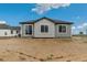 Rear exterior showcasing gray siding with black trim and large windows under a bright blue sky at 1613 Bloom St, Brighton, CO 80601