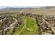 Aerial view showcasing a golf course community with lush greenery and manicured landscaping at 6668 Fairways Dr, Longmont, CO 80503