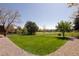 Lush backyard with a manicured lawn, mature trees, a wooden fence, and views of the adjacent green space at 6668 Fairways Dr, Longmont, CO 80503