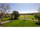 Sprawling backyard featuring a well-maintained lawn, a fence, mature trees, and golf course views at 6668 Fairways Dr, Longmont, CO 80503