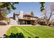 Expansive backyard with lush green grass, a patio, a two-story deck, and mature trees at 6668 Fairways Dr, Longmont, CO 80503