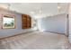Basement showcasing neutral carpet, windows, lighting, and built-in shelves at 6668 Fairways Dr, Longmont, CO 80503