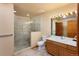 Bright bathroom featuring a glass-enclosed shower, neutral tones, and a modern vanity with a light-up mirror at 6668 Fairways Dr, Longmont, CO 80503