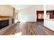 Inviting living room with a brick fireplace and wood floors, adjacent to an open kitchen area at 6668 Fairways Dr, Longmont, CO 80503