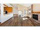 Open concept living room features wood flooring, a brick fireplace, and easy access to the kitchen at 6668 Fairways Dr, Longmont, CO 80503