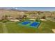 Aerial view of well-maintained blue tennis courts, a playground, and a basketball court in the community at 6668 Fairways Dr, Longmont, CO 80503