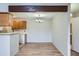 Open-concept dining area featuring laminate floors and contemporary chandelier next to an equipped kitchen at 10150 E Virginia Ave # 301, Denver, CO 80247