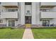 Apartment building entrance with number 7 and unit numbers is bordered by grassy lawn at 10150 E Virginia Ave # 301, Denver, CO 80247