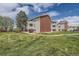 A well-maintained apartment building with brick accents and multiple balconies is surrounded by lush green grass at 10150 E Virginia Ave # 301, Denver, CO 80247