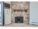 Close-up of stone fireplace with wooden mantel and modern laminate flooring at 10150 E Virginia Ave # 301, Denver, CO 80247