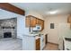 Kitchen with white appliances, light wood cabinets, breakfast bar and fireplace in the background at 10150 E Virginia Ave # 301, Denver, CO 80247