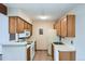 Compact kitchen with light wood cabinets, white appliances and neutral countertops offers functionality at 10150 E Virginia Ave # 301, Denver, CO 80247