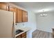 A view of the kitchen sink, cabinets and dishwasher that leads into the dining area with modern light fixture at 10150 E Virginia Ave # 301, Denver, CO 80247