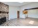 Open-concept living room with stone fireplace, laminate floors, and breakfast bar at 10150 E Virginia Ave # 301, Denver, CO 80247