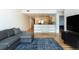 An open floor plan features a gray couch, a kitchen bar, and wood floors at 3701 Arapahoe Ave # 318, Boulder, CO 80303