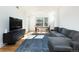 A bright living room features wood floors, a gray couch, and a TV at 3701 Arapahoe Ave # 318, Boulder, CO 80303