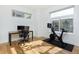 Bright home office featuring light wood floors, a desk, and a stationary bike at 3701 Arapahoe Ave # 318, Boulder, CO 80303