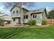 Lush backyard with a wood deck, a beautiful lawn, mature trees, and access to the house at 6167 S Pierson St, Littleton, CO 80127