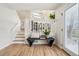 Inviting home entryway featuring a bench, hardwood floors, staircase, and natural light from the front door at 6167 S Pierson St, Littleton, CO 80127