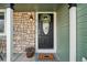 Charming front door with stone accents, decorative wreath and vibrant potted plants for a welcoming entrance at 6167 S Pierson St, Littleton, CO 80127