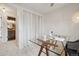 Bright home office features a glass top desk, modern lighting, and a view into the bathroom at 6167 S Pierson St, Littleton, CO 80127