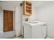 Laundry room with white washer and dryer and open shelving at 6167 S Pierson St, Littleton, CO 80127