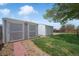 Spacious backyard featuring two storage sheds, lush green grass, and a charming stone pathway at 18714 E Utah Cir, Aurora, CO 80017