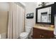 Bathroom with tan shower curtain, honey-toned vanity, and unique framed mirror at 18714 E Utah Cir, Aurora, CO 80017