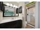 Well-lit bathroom with sleek vanity, modern fixtures, and tiled shower with glass door at 18714 E Utah Cir, Aurora, CO 80017