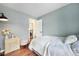 Bedroom with wood floors, complemented by a stylish lamp, vanity, and a glimpse into a laundry area at 18714 E Utah Cir, Aurora, CO 80017