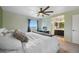 Bright bedroom featuring a ceiling fan, large window, and connected bathroom at 18714 E Utah Cir, Aurora, CO 80017