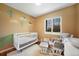 Warm Bedroom featuring a white crib, comfy glider, and bright, natural light at 18714 E Utah Cir, Aurora, CO 80017