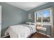 Cozy bedroom featuring a comfortable bed, natural light, and a charming decorative shelf at 18714 E Utah Cir, Aurora, CO 80017