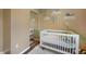 Warm Bedroom featuring a white crib, mirrored closet, and whimsical wall decorations at 18714 E Utah Cir, Aurora, CO 80017