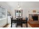 Bright dining area features a brick fireplace, wood floors, and a modern light fixture at 18714 E Utah Cir, Aurora, CO 80017