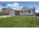 Charming home with a well-manicured lawn and a cozy front porch, creating a welcoming entrance at 18714 E Utah Cir, Aurora, CO 80017
