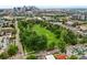 Aerial shot of a city park with lush trees, green spaces, and cityscape in the background at 2131 Eliot St, Denver, CO 80211