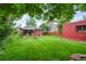Spacious backyard with a lush lawn, trees, dining area and neighboring houses in the background at 2131 Eliot St, Denver, CO 80211