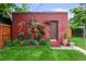 Quaint backyard featuring a brick outbuilding adorned with climbing roses and a beautifully landscaped garden at 2131 Eliot St, Denver, CO 80211