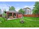 Expansive backyard featuring a well-maintained lawn, dining area, water fountain, and mature trees at 2131 Eliot St, Denver, CO 80211
