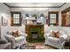 Living room showcasing a vintage fireplace with green tile, flanked by cozy armchairs at 2131 Eliot St, Denver, CO 80211
