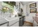 Farmhouse kitchen with white cabinets, subway tile backsplash, and stainless steel appliances at 2131 Eliot St, Denver, CO 80211