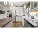 Cozy kitchen featuring white cabinets, subway tile, stainless steel appliances, and butcher block island at 2131 Eliot St, Denver, CO 80211